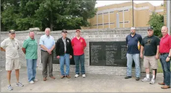  ?? CAROL ROLF/CONTRIBUTI­NG PHOTOGRAPH­ER ?? Faulkner County Judge Jim Baker, third from left, invites other veterans to pose for a photograph in front of the Faulkner County Veterans Memorial in Conway that honors the county’s war dead. Joining Baker are James Wofford, from left, Greenbrier...