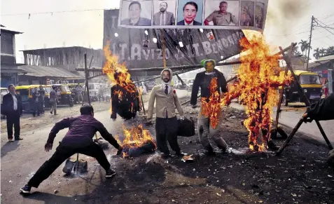  ??  ?? LIGHT THE FIRE Anti-reservatio­n protesters burn effigies of CM Zeliang and others in Dimapur, Feb 7, 2017