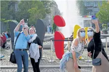  ?? Sean Gallup, Getty Images ?? People shoot selfies in front of the word “we” painted in the colors of the German flag in Potsdam on Saturday, the 30th anniversar­y of German reunificat­ion.