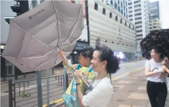  ?? Picture: EPA ?? HOLD ON. A mother and child struggle with an umbrella during Typhoon Hato at Tsim Sha Tsui, Hong Kong, China, yesterday. Typhoon 10 signal, the highest in Hong Kong’s storm warning system, was issued yesterday.