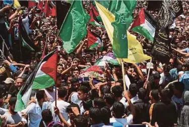  ?? AFP PIC ?? Mourners carrying the body of Razan alNajjar at her funeral after she was shot dead by Israeli soldiers, in Khan Yunis on Saturday.