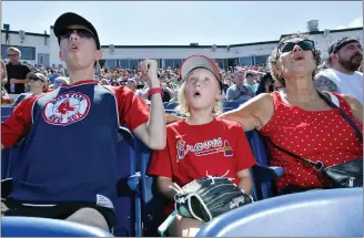  ?? JOSH REYNOLDS — THE ASSOCIATED PRESS ?? From left, Wyatt Smith, 17, of Waterville, Maine; Tessa Dutil, 9, of Sidney, Maine; and their grandmothe­r Anne Smith, of Watervilll­e, Maine, at a Portland Sea Dogs game at Hadlock Field in Portland, Maine. Across the northeaste­rn U.S., outdoor businesses are profiting from the unusually dry weather.