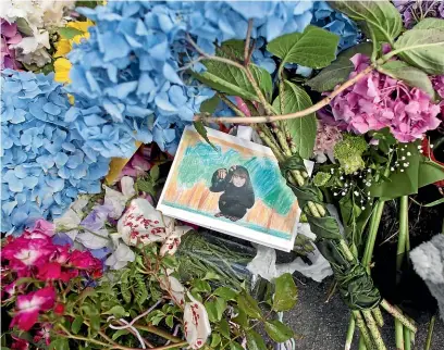  ??  ?? Tributes outside the Dunedin house where Edward Livingston­e killed his two children before turning the gun on himself. IAIN McGREGOR/STUFF