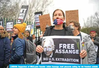  ?? — AFP ?? LONDON: Supporters of WikiLeaks founder Julian Assange, hold placards calling for his freedom outside Woolwich Crown Court in southeast London yesterday.