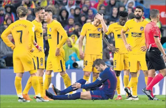  ??  ?? LAMENTOS. Los jugadores del Atlético se lamentan mientras que Piqué, en el suelo, se queja de la rodilla derecha.