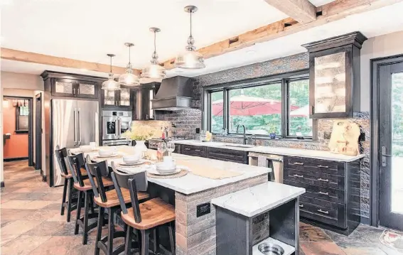  ?? Courtesy of Saratoga Kitchen and Baths ?? Michael Hinkley's kitchen island in Ballston Spa includes a marble dog bowl station for their furry friend.