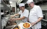  ?? AL DIAZ adiaz@miamiheral­d.com ?? Quintin Larios, right, in the kitchen with Manuel Arevalo. The owners of Larios, who shuttered their businesses in January 2015 over financial troubles, have returned as employees of La Fragua Restaurant off Flagler Street.