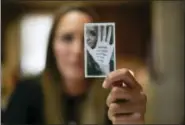  ?? DAKE KANG — THE ASSOCIATED PRESS ?? Koriann Evans, a former drug addict, holds up a photo of herself with an anti-addiction message written on her hand at her home in Bellevue, Ohio.