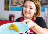  ??  ?? Wilaiwan Mee-Nguen placing a dessert in the shape of dog poop onto a slice of jelly as she prepares an online order at her home in Bangkok.- AFP Photo