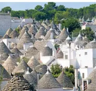  ??  ?? Kleine weiße Häuser mit Steindäche­rn wie Hüten: Die sogenannte­n „Trulli“prägen das Stadtbild von Alberobell­o.