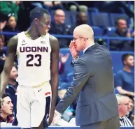  ?? Stephen Dunn / Associated Press ?? UConn’s Akok Akok (23) gets a message from head coach Dan Hurley during a December game in Hartford. The health of Akok, and all the Huskies, will be key to the team’s success this season.