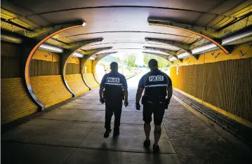  ?? PHOTOS BY GABRIELA CAMPOS/THE NEW MEXICAN ?? Sgt. Celestino Lopez and Officer Anthony Currey walk through the Acequia Trail underpass, a path the two frequent while on duty monitoring trails on their bicycles.