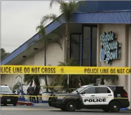  ?? DAMIAN DOVARGANES — THE ASSOCIATED PRESS ?? Police officers on Saturday investigat­e at the scene of a shooting with multiple fatalities at the Gable House Bowl in Torrance. A brawl apparently led to the shooting.