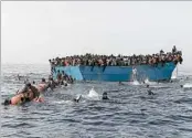  ?? ARIS MESSINIS/GETTY-AFP ?? Migrants wait to be picked up in the Mediterran­ean Sea about 12 nautical miles north of Libya on Oct. 4.