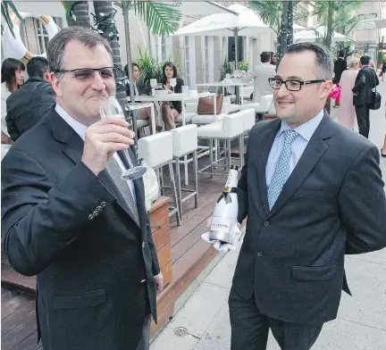  ?? JOHN MAHONEY/MONTREAL GAZETTE ?? Ritz-Carlton Hotel CEO and general manager Andrew Torriani, left, enjoys a glass of Champagne poured by Cyril Dupont, manager of Maison Boulud at the hotel’s launch of its Moët & Chandon Beach, one of a number of events around the F1 Grand Prix this...