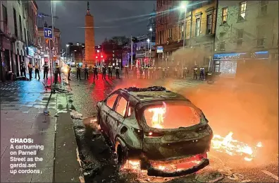  ?? ?? Chaos:
A carburning on Parnell Street as the gardaí set up cordons