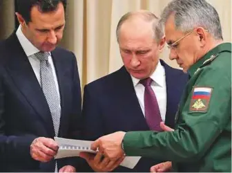  ?? AP ?? Putin, Al Assad and Russian Defence Minister Sergei Shoigu look at a document during their meeting in the Bocharov Ruchei residence in the Black Sea resort of Sochi, Russia.