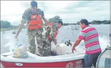  ??  ?? Militares se encargaron de distribuir kits de víveres a las comunidade­s de Yabebyry, a las que llegaron en lanchas.