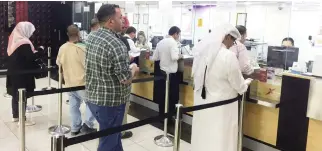  ??  ?? People exchange money at a financial firm in Doha, Qatar. (Reuters)