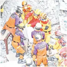  ?? — AFP photo ?? The first of two bodies is removed by an earthquake-damaged building in the Taiwanese city of Hualien.