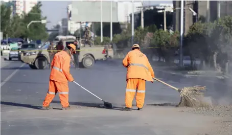  ?? AP ?? Afghan municipali­ty workers after bomb explosion on a road that targeted a bus carrying local TV station employees in Kabul on Saturday.