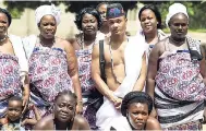  ?? AP ?? Kieron Graham (centre) poses for a photo in Benin, West Africa, after participat­ing in an African naming ceremony with the High Priest of Voodoo during his heritage travel trip inspired by his AncestryDN­A results yesterday.