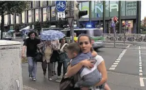  ??  ?? People run from the shopping centre in panic as shots ring out in central Munich