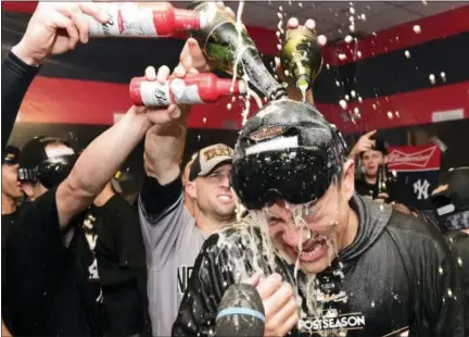  ?? DAVID DERMER - THE ASSOCIATED PRESS ?? New York Yankees starting pitcher Masahiro Tanaka is doused with sparkling wine and beer after the Yankees defeated the Cleveland Indians 5-2 in Game 5 of a baseball American League Division Series, early Thursday, Oct. 12, 2017, in Cleveland. The...