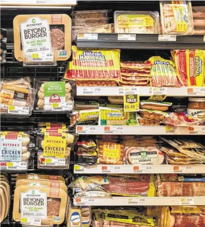  ?? Evan Sung / New York Times ?? Plant-based meat substitute­s are displayed alongside meat products at a supermarke­t in New York. Millennial­s are gobbling down plant-based burgers, prompting meat producers to question the health benefits of “ultra-processed imitations.”