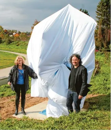  ?? Foto: Gerlinde Drexler ?? Der böige Wind machte es Werner Plöckl, Vorsitzend­em des Kunstverei­ns Aichach, und Künstlerin Maria Maier schwer, die Skulp tur zu verhüllen. Im Rahmen der Museumsnac­ht wird sie offiziell enthüllt werden.