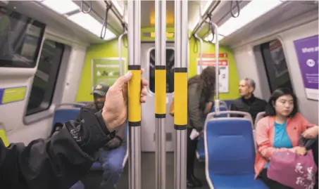  ?? Photos by Jessica christian / The chronicle ?? BART’s new cars feature poles for riders to hold onto and colorful blue and green plastic molded seats with lumbar support.