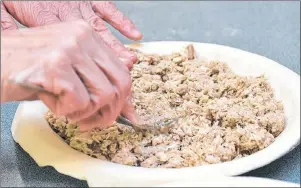  ?? COLIN MACLEAN/JOURNAL PIONEER ?? The mixture of pork, chicken and spices are added to the pies before baking.