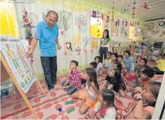  ?? FILE PHOTO ?? Children of migrant workers attend a lecture by volunteer Pairoj Chantharaw­ong at a constructi­on site in Chatuchak district.