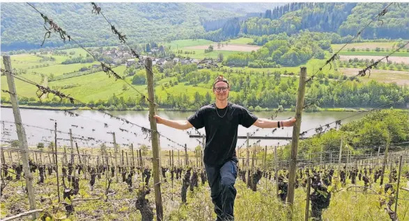  ?? FOTO: FELIX KUNZ ?? Traumhafte­r Blick: Fynn La Breche an seinem Arbeitspla­tz an der Saar bei Serrig. Der 24-Jährige hat sich gegen das Studium und für die Ausbildung zum Winzer entschiede­n.