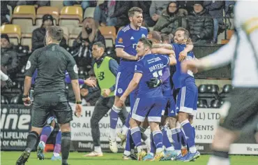  ?? ?? GET IN: Town celebrate Aaron Martin’s opening goal at Meadow Lane on Tuesday night. Photos: Marcus Branston.