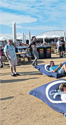  ??  ?? Taking it easy: Spectators relax on beanbags during the first round of the Open at sunny Carnoustie