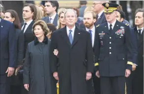  ?? Suzanne Cordeiro / AFP/Getty Images ?? Former President George W. Bush, former First Lady Laura Bush and family wait as the casket of former President George W.H. Bush is carried off the train, upon arrival for the interment ceremony at the George H.W. Bush Presidenti­al Library and Museum in College Station, Texas, on Thursday.