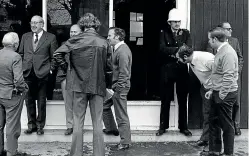  ?? PRESS ARCHIVES ?? People gather outside the consulate after the fire, with Quirk second from left. A policeman stands guard.