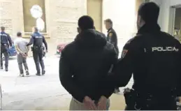  ?? CUERPO NACIONAL DE POLICÍA ?? Dos detenidos salen de declarar esposados y custodiado­s por agentes.