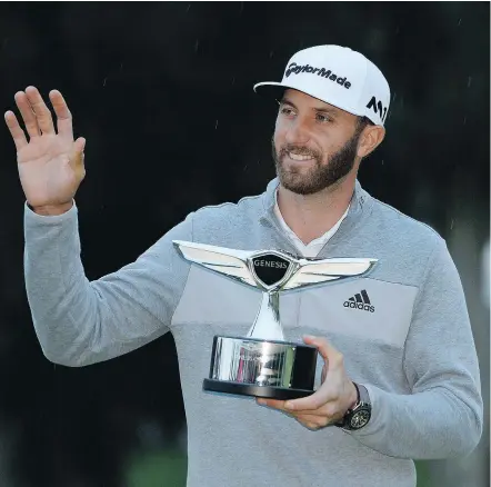  ?? — GETTY IMAGES ?? Dustin Johnson poses with the trophy on Sunday after recording a five-shot victory at the Genesis Open, played at the Riviera Country Club in Pacific Palisades, Calif.