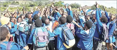  ?? ?? Holy Rosary Primary School pupils celebrate with all wanting to lay their hands on the trophy they won in the Under-10 category during the Montigny Athletics Schools Competitio­n.