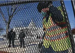  ?? Matt Mcclain / Washington Post ?? Workers put up fencing outside the Capitol in the wake of rioting by members of a pro-president Donald Trump mob.