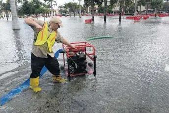  ?? JIM RASSOL/STAFF FILE PHOTO ?? Mike Cerruto starts a pump in a parking lot in Boynton Beach to help remove water after an overnight storm in 2014.