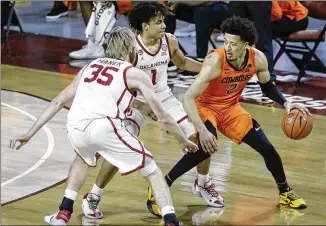  ?? GARETT FISBECK/AP ?? Oklahoma State freshman guard Cade Cunningham goes against Oklahoma forward Brady Manek and forward Jalen Hill on Saturday in Norman, Oklahoma. Cunningham scored 40 points.