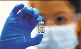  ?? FRANK AUGSTEIN Associated Press ?? A NURSE displays a vial of the Pfizer- BioNTech vaccine. Pfizer has said it will take only a few days to distribute millions of doses to points across the U. S.