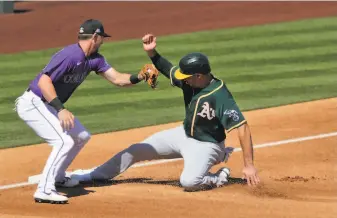  ?? Photos by Carlos Avila Gonzalez / The Chronicle ?? A’s first baseman Matt Olson, who had doubled, reaches third safely after Matt Chapman’s firstinnin­g flyball. Olson was 1for3 in his second game of the Cactus League season.