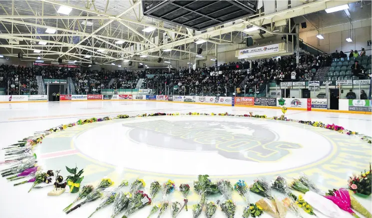  ?? JONATHAN HAYWARD / THE CANADIAN PRESS ?? Flowers lie on the ice as people gather for a vigil at the Elgar Petersen Arena.