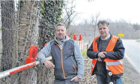  ?? FOTO: BARBARA BAUR ?? Sie sind Geburtshel­fer für Kröten, Frösche und Molche: Patrick Müller (links) und Wolf Mannes kümmern sich darum, dass die Straße durch den Weingartne­r Wald zwischen Hagnau und Ittendorf während der Amphibienw­anderung gesperrt ist.