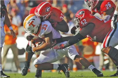  ?? STAFF PHOTO BY C.B. SCHMELTER ?? Tennessee running back Jeremy Banks is hit by Georgia linebacker Monty Rice (32) as defensive lineman Tyler Clark (52) closes in during their SEC East matchup on Sept. 29 in Athens. The Vols averaged 2.6 rushing yards per carry that day and lost the game 38-12.