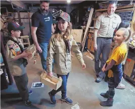  ?? AP FILE PHOTO ?? STRICTLY BUSINESS: Tatum Weir, center, carries a tool box she built as her twin brother, Ian, left, follows after a Cub Scout meeting in Madbury, N.H. Their troop is part of an ‘early adopter’ program to allow girls to become Cub Scouts and eventually...